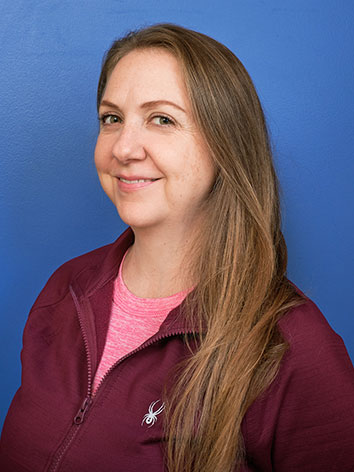 Amy Arnold of Prana Endura standing in front of a blue background